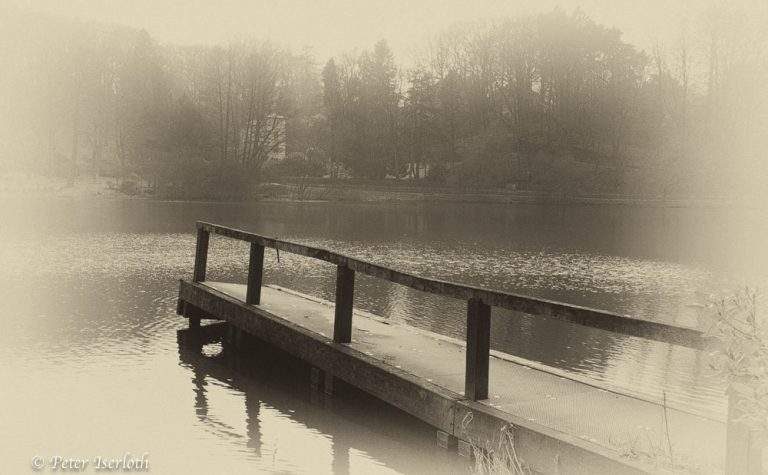 Fotografie eines Steges in in einen See ragt.