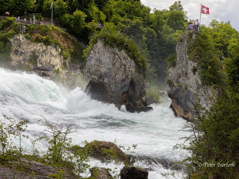 Rauschen des Rheinfalls mit Felsen und Blick auf die Schweizer Flagge.